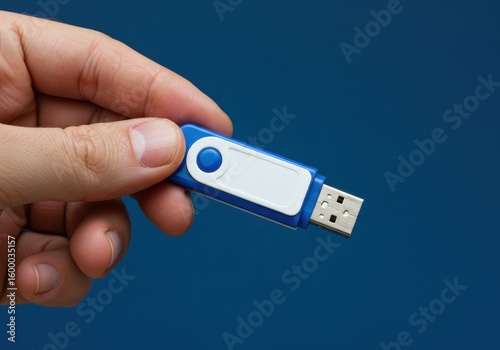 Hand holding a blue and white usb flash drive