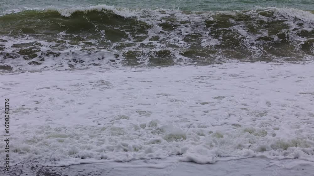 Slow motion dark waves crashing onto the shore line Slow motion dark waves crashing onto the shore line