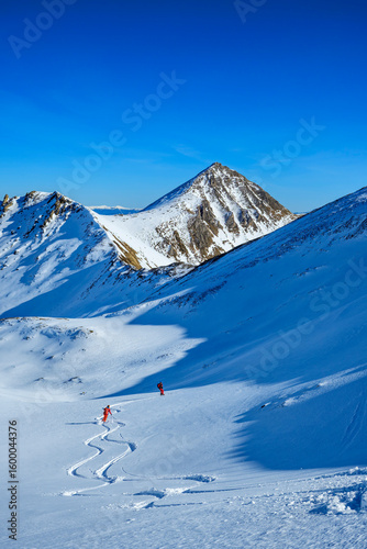 Skiers descending snowy slopes in Lower Tauern Austria on a sunny day