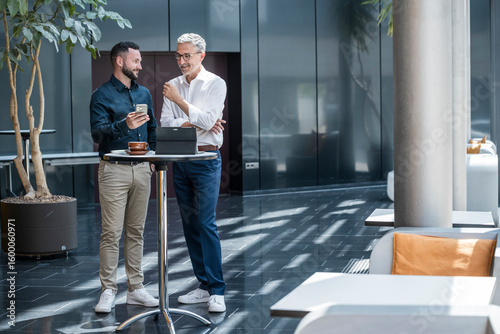 Manager giving advice to team member during business discussion in modern office