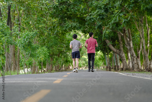 Wallpaper Mural Happy active men jogging outdoor in nature green park. Gay couple exercising running together in the morning. Healthy lifestyle of two young people is exercise in countryside. Gay couple enjoyment. Torontodigital.ca