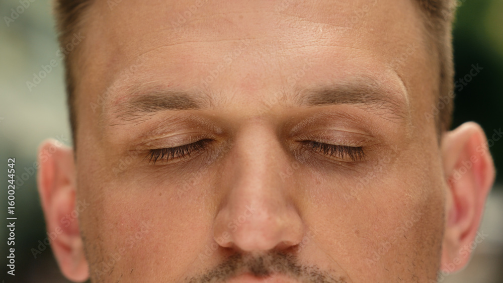 Obraz premium Eyes close up closed human Caucasian man cropped view eyesight guy close eye outdoors clear vision health laser correction medicine gaze blink face skin care male calm serene portrait in city outside