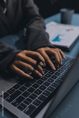 Close up of business woman hands typing on laptop computer and digital tablet, searching and surfing the internet on office desk, online working, telecommuting, freelancer at work concept