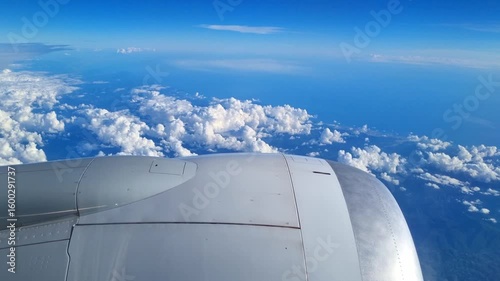 Scenic Aerial View Over Clouds from Airplane Window in Clear Sky