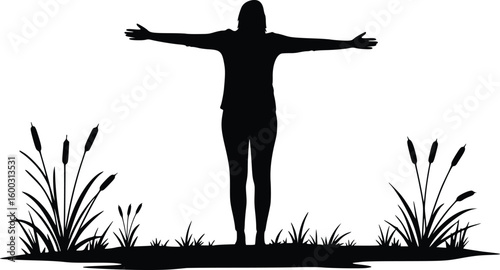 Silhouette of a person standing outdoors with arms raised in freedom amid grass and nature