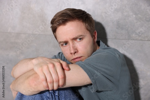 Scared man suffering from paranoia at home