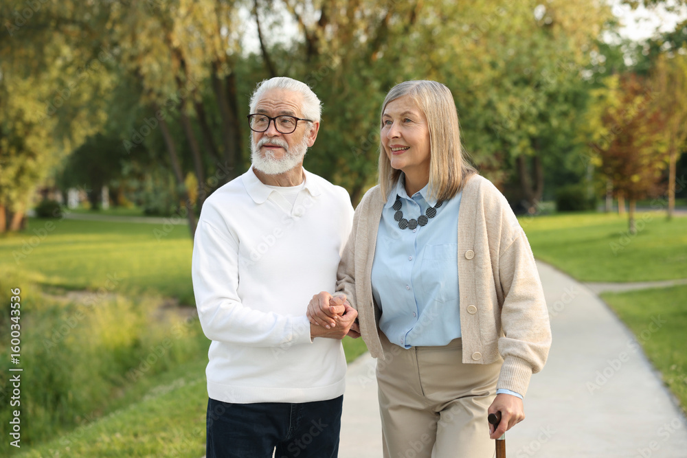 Lovely senior couple walking together in park Lovely senior couple walking together in park