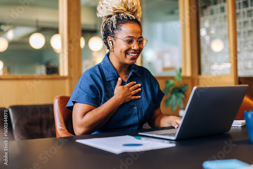 Konstfotografi Smiling woman enjoying a video call with a laptop in a cozy office