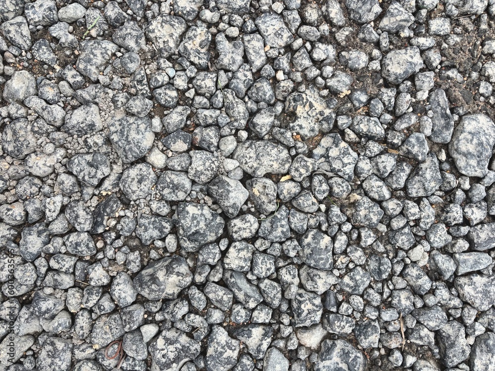 A close-up view of a pile of crushed gravel stones in various shades of gray and brown. Perfect for use in construction, landscaping, or backgrounds in industrial-themed design work. A close-up view of a pile of crushed gravel stones in various shades of gray and brown. Perfect for use in construction, landscaping, or backgrounds in industrial-themed design work.