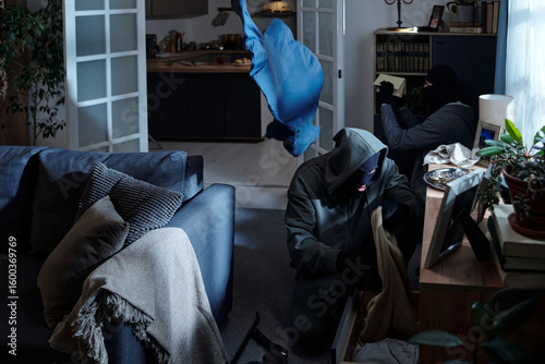 Obraz na plátne Group of masked men breaking into modern living room, searching through drawers