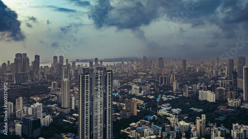 Aerial cinematic image of Mumbai during the monsoon season, featuring dramatic clouds over the city skyline. Ideal for themes like weather, travel, cityscapes, and dramatic skies.