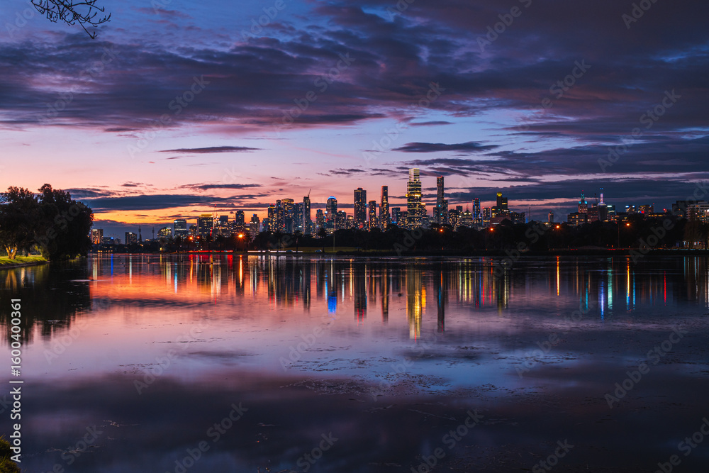 Fototapeta premium Melbourne, Victoria, Australia - Night view of Melbourne city lights reflecting on Albert Park Lake, with vivid colors in the sky.