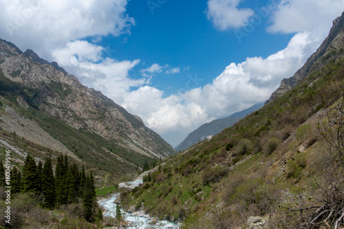 Ala-Archa Park, mountain landscape, winding river, rugged slopes, dense forest, alpine vegetation, and expansive sky, ideal for trekking, hiking, mountaineering, outdoor adventure, and nature lovers