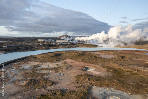 Aerial view of geothermal plumes rising amidst the stark, otherworldly landscape, with turquoise waters contrasting against the rugged terrain, Selfoss, SveitarfÃ©lagiÃ° Ãrborg, Iceland.