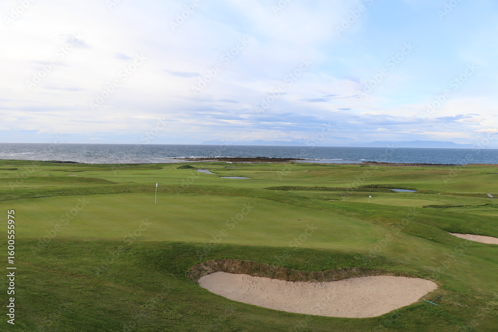 Empty sudurnesja golf cours in the south west of Iceland. The green course contrasting with the grey blue ocean and the white blue sky. Empty sudurnesja golf cours in the south west of Iceland. The green course contrasting with the grey blue ocean and the white blue sky.