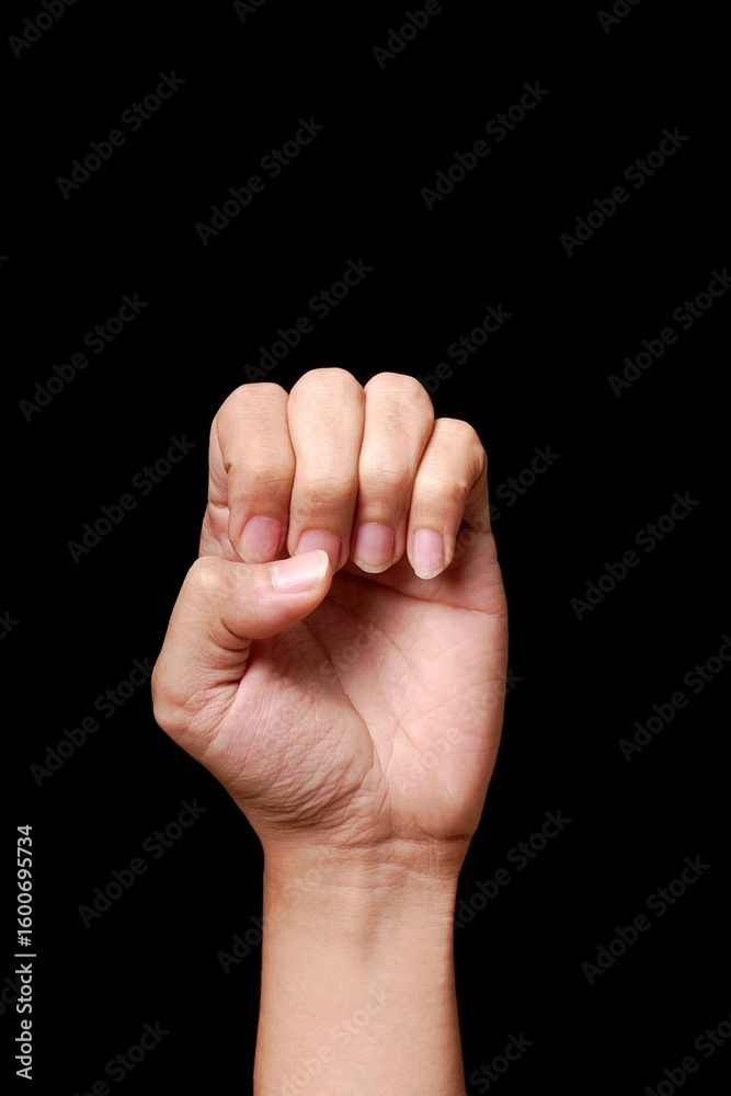 Fototapeta premium Hand making a fist on black background.