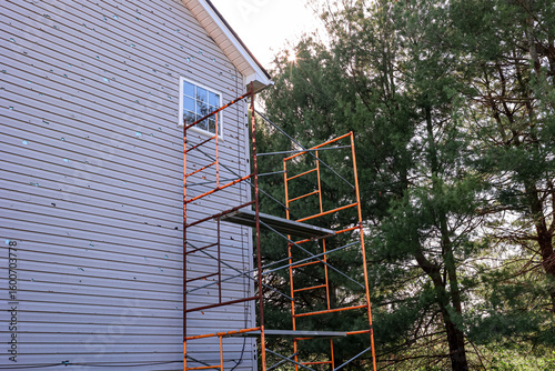 Bild auf Leinwand Scaffold On The Side of A House To Repair Vinyl Siding