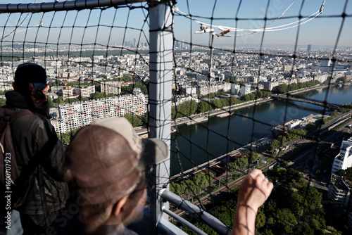 Paris cityscape view from eiffel tower with tourists observing seine river