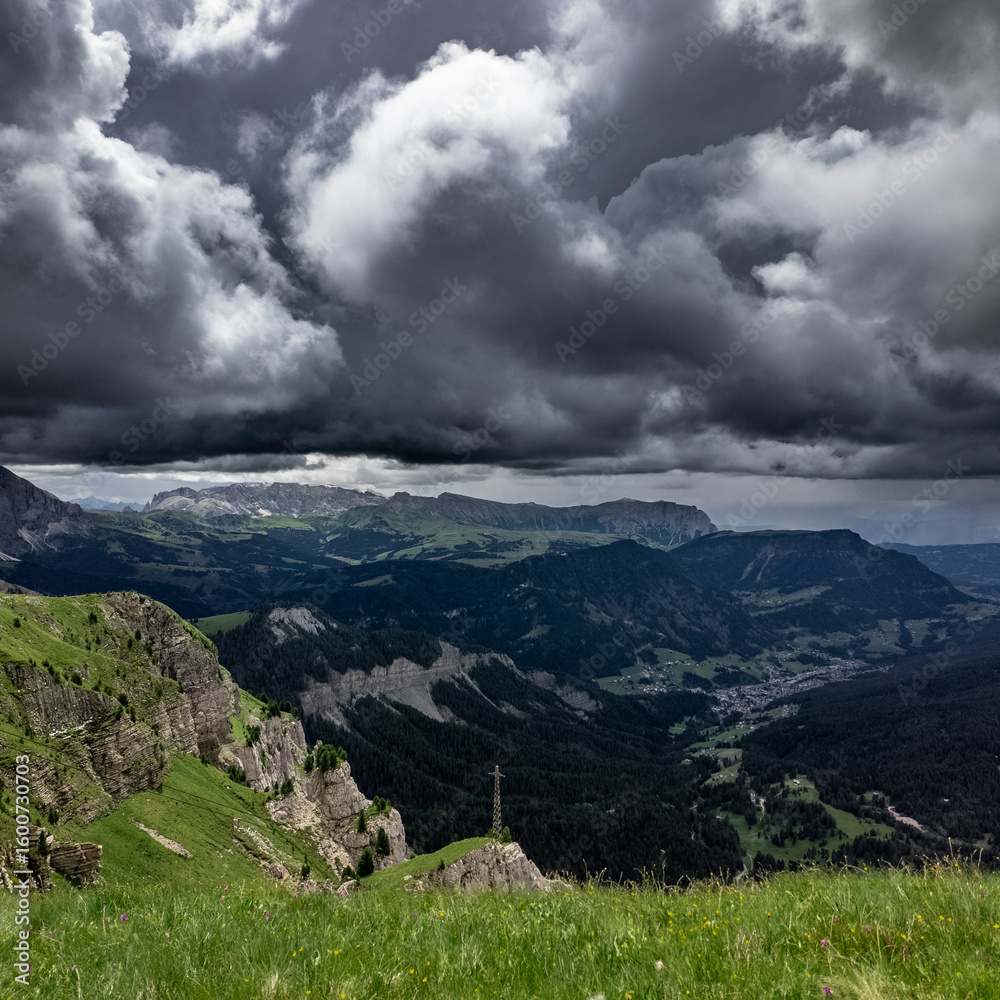 Fototapeta premium dark storm clouds rolling over alpine valley near Seceda, Dolomites, Italy