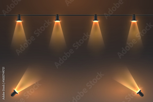 Stage spotlights with a warm glow on a dark background.