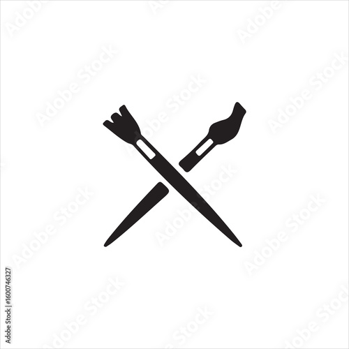 Two black paintbrushes crossed on white background artist painting