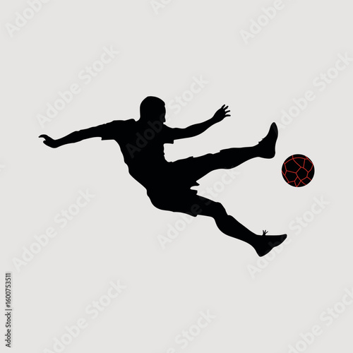 Dynamic silhouette of a soccer player kicking the ball in mid air