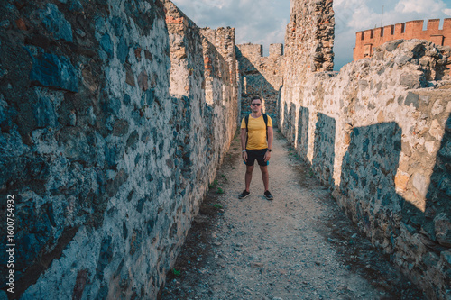 Man at fortress ruins of the historical Red Tower - Kizil Kule, in Alanya Castle, the famous touristic place.