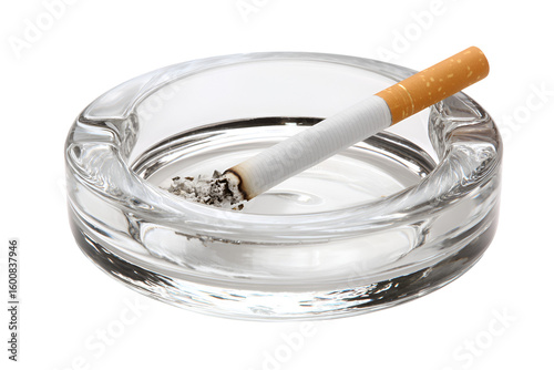 A burning cigarette in a glass ashtray