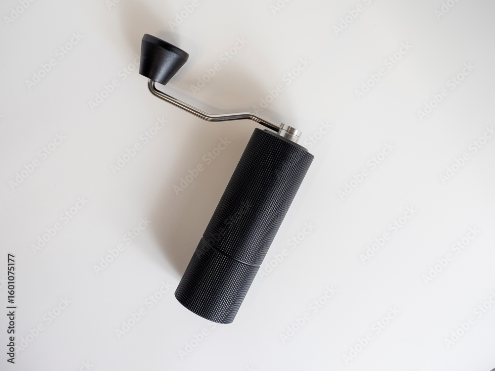 Fototapeta premium manual coffee grinder black on a white background, top view, flat lay