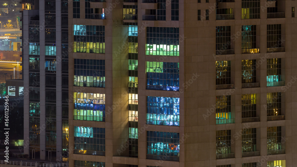 Windows of the multi-storey building of glass and steel lighting inside and moving people within timelapse Windows of the multi-storey building of glass and steel lighting inside and moving people within timelapse