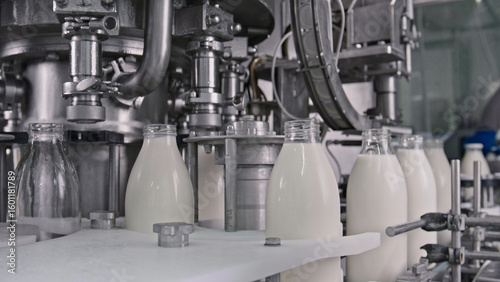Bottling machine filling glass bottles with fresh