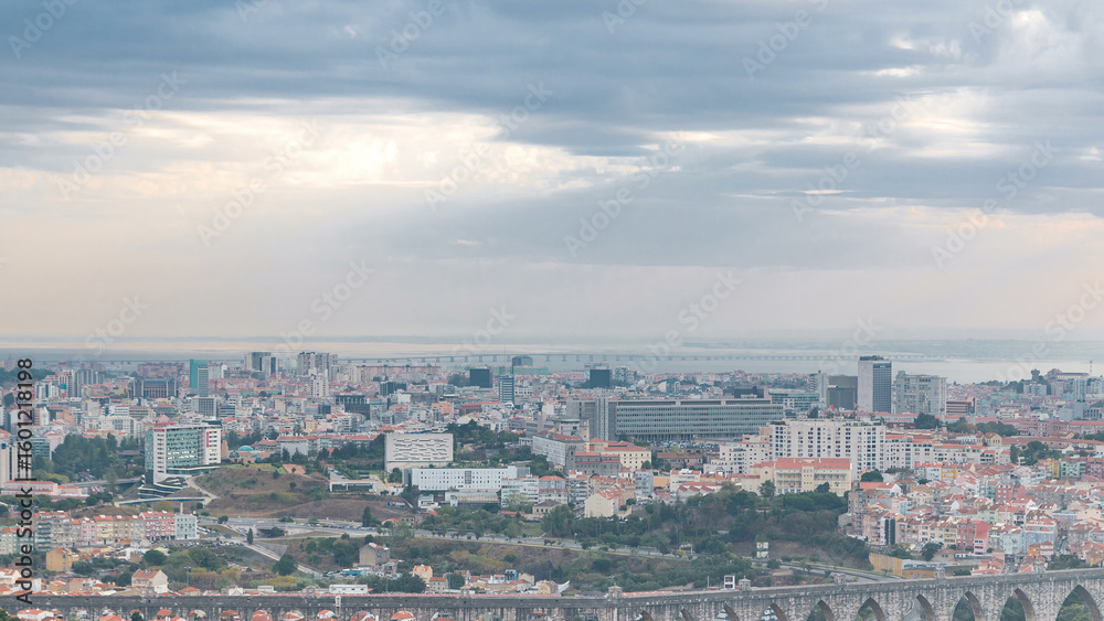 Obraz premium Panoramic overview during sunrise over Lisbon and Almada from a viewpoint in Monsanto morning timelapse.