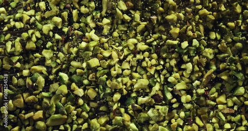 Falling Crushed Pistachios in Slow Motion of Green Nut Granules Dropping and Spreading, Ideal for Gourmet Food, Baking Ingredients, and Organic Snack Concepts