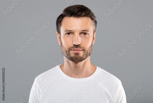 Bild auf Leinwand Portrait of handsome bearded man over grey studio background, empty space