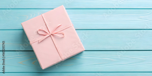 Pink gift box with string on blue wooden background