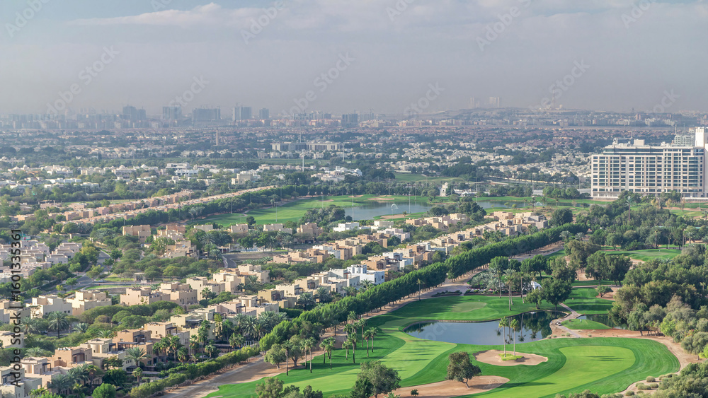 Fototapeta premium Aerial view to villas and houses with Golf course with green lawn and lakes timelapse