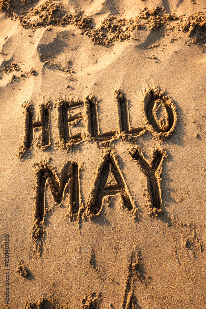Fototapeta premium HELLO MAY Drawn in Playful Letters in Wet Sand with Clean Texture and Warm Light