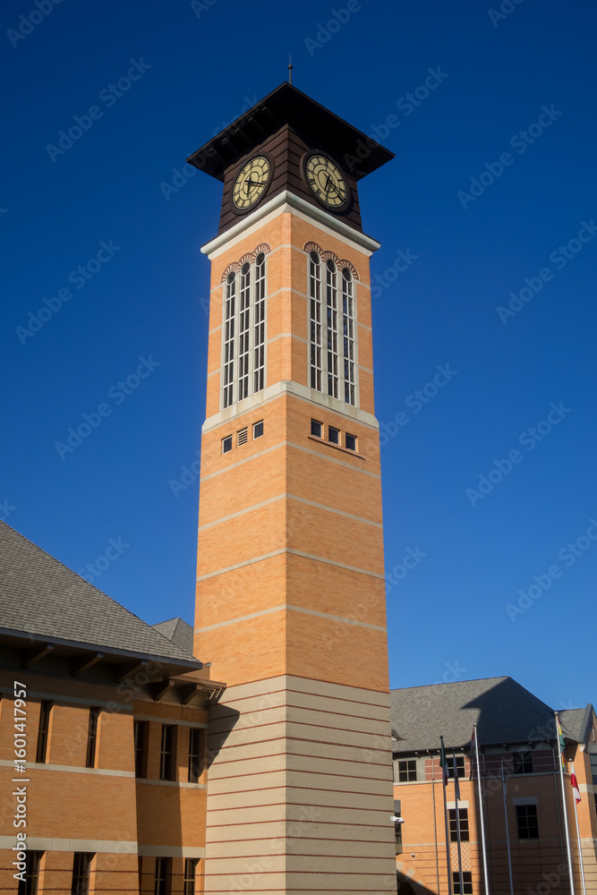 Obraz premium Richard M. DeVos Center building, clock tower against blue sky in Grand Valley state university campus, Grand Rapids, Michigan
