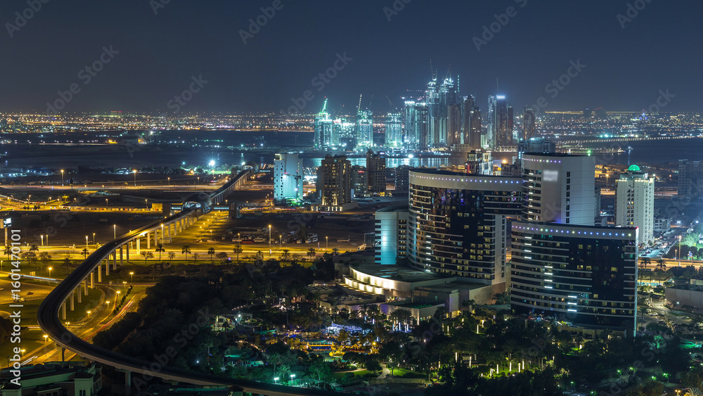 Fototapeta premium Night view of new modern buildings and lights in luxury Dubai city, United Arab Emirates Timelapse Aerial