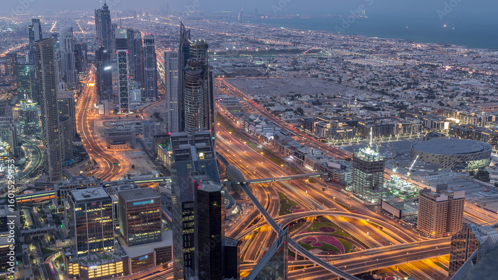 Obraz premium Dubai Downtown skyline futuristic cityscape with many skyscrapers and Burj Khalifa aerial night to day timelapse.