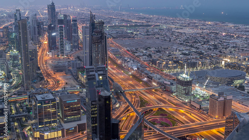 Dubai Downtown skyline futuristic cityscape with many skyscrapers and Burj Khalifa aerial night to day timelapse.