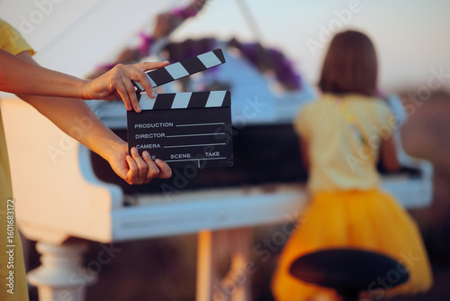 Movie Scene Where a Little Girl Plays the Piano in a Lavender Field. Crew filming a music video in a beautiful location with a pianist 
