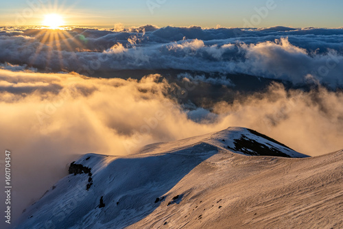 Sunset over the Chimborazo volcano with the light on the ice in an amazing and totally natural high mountain scene. Invitation to adventure, the call to climb and discover.