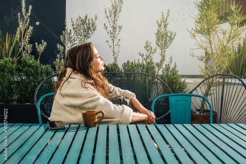 Young woman Sunbathing for vitamin D in autumn fall on a rooftop