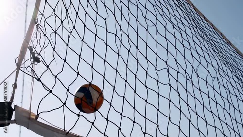 Volleyball in net, bright sky background