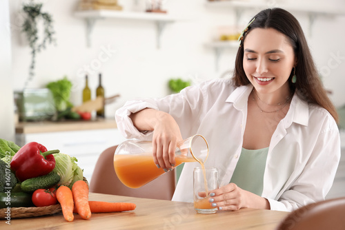 Young woman pouring vegetab...