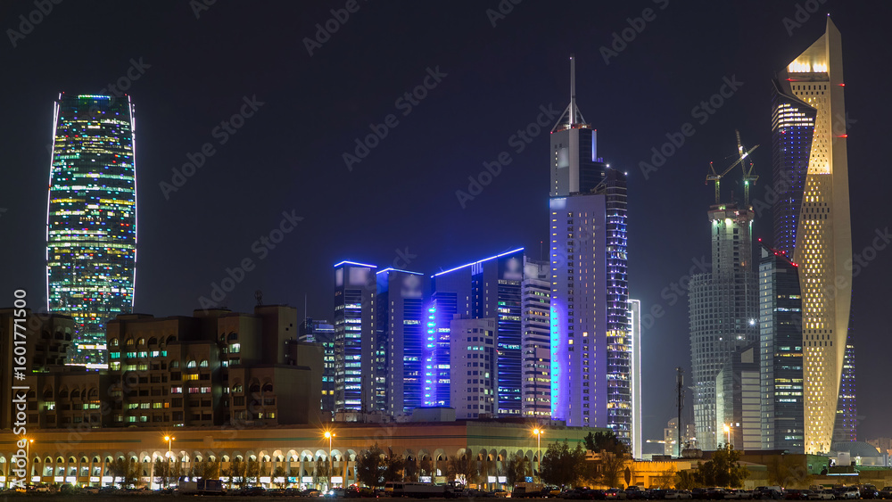 Fototapeta premium Skyline with Skyscrapers day to night timelapse in Kuwait City downtown illuminated at dusk. Kuwait City, Middle East