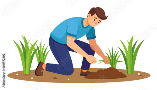A young man in a blue shirt kneeling to plant a green seedling in the garden soil.