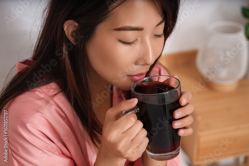 Young Asian woman drinking ...