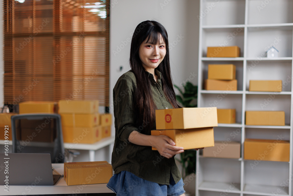 Startup small business entrepreneur or freelance Asian woman holding parcel box, Young success Asian woman with her online marketing packaging box and delivery Startup small business entrepreneur or freelance Asian woman holding parcel box, Young success Asian woman with her online marketing packaging box and delivery
